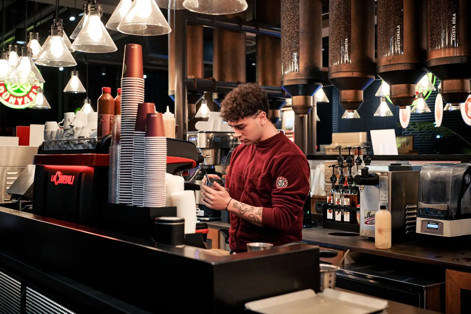 A barista making coffee behind the counter of a café